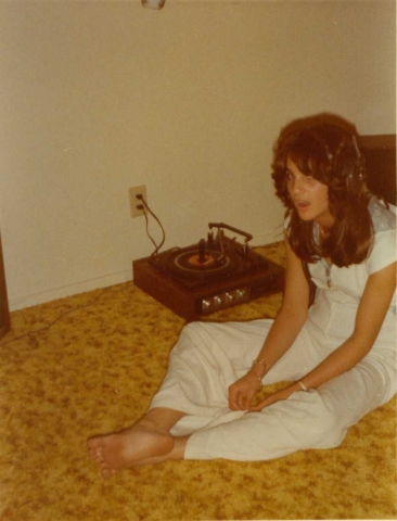 Sherie Brooks listening to a record player. Love those earbuds...oops earphones! 